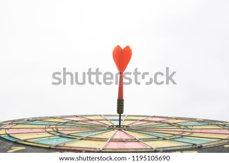 Red dart arrow on center of dartboard isolated on white background
