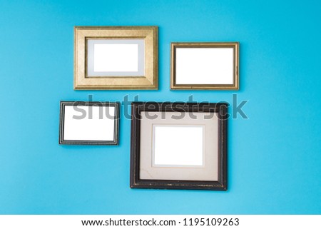Blank empty golden and wooden frames on blue background. Art gallery, museum exhibition white clipping path