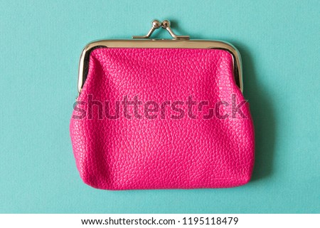Pink wallet on turquoise background . Close up. Top view.