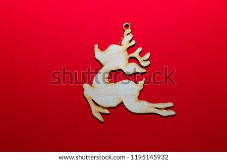Christmas wooden toy deer on a red background