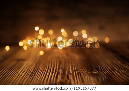 Golden christmas lights on rustic wooden table for a background