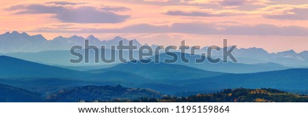 Wide angle panorama autumn forest,misty hills mountain tops in pink dawn Royalty-Free Stock Photo #1195159864