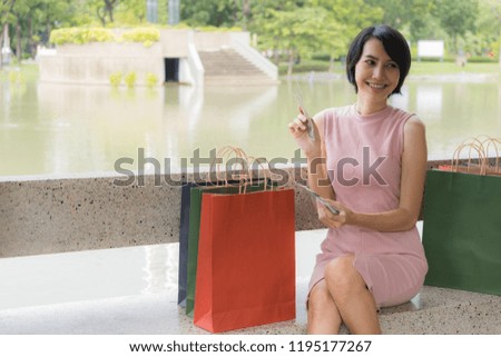 Young woman sitting and checking money after finished shopping in the park