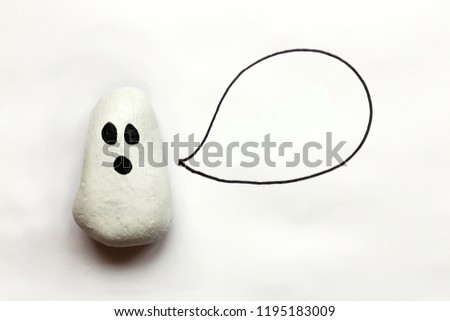 A cartoon painted Halloween Ghost rock is isolated on a white background with a speech bubble that is empty.
