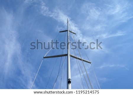 Looking up the mainmasts over blue sky background.