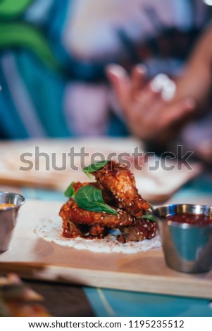 Young woman preparing and eating mexican food in a street restaurant.  Mexican tacos, nachos and wings.