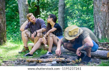 Company friends camping forest. Man brutal bearded hipster prepares bonfire in forest. How build bonfire outdoors. Camping weekend leisure. Ultimate guide to bonfires. Arrange woods twigs or sticks.