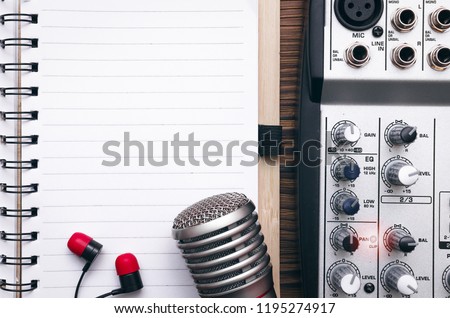 Audio recording studio concept. Karaoke. Song lyrics. Microphone, audio sound mixer, blank page notepad and headphones on the table. Royalty-Free Stock Photo #1195274917