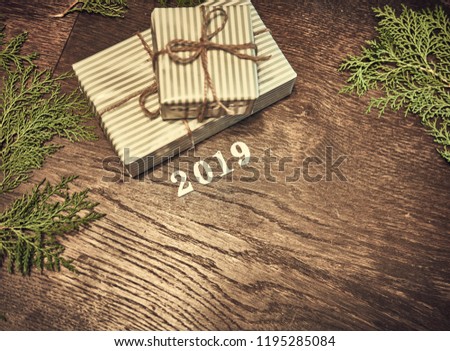Christmas composition. 2019 Christmas gifts, pine branches, toys on wood background. Flat lay, top view