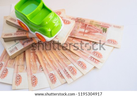 bank and russian money. Car expenses concept.Toy car on the background of banknotes.Model of car against background of monetary denominations of 5000 rubles of Russia. Concept of car loans, leasing