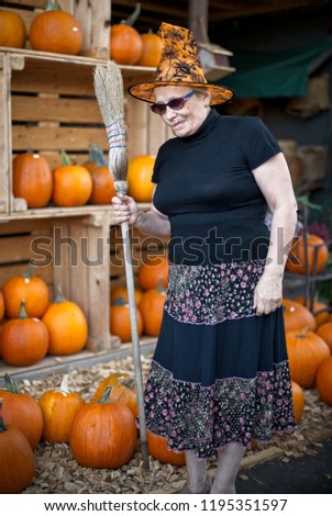 Evil witch with pursed lips holding broom. Halloween personage