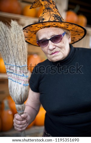 Evil witch with pursed lips holding broom. Halloween personage