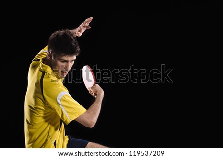young man tennis-player in play on black background with lights Royalty-Free Stock Photo #119537209