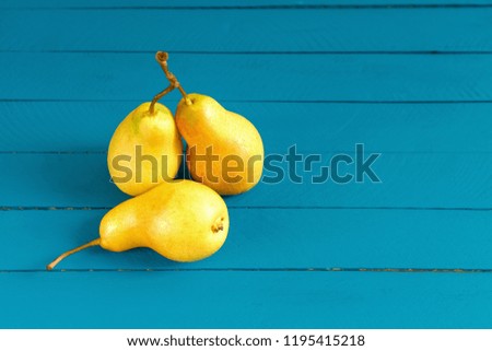 Fresh pears. Pears harvest. Fruit background. Yellow pear on blue wood background. Pear home decor. Yellow decorative pear.