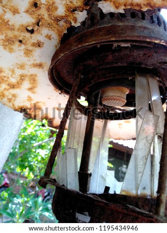 The broken bulb and glass splinters. Classic Old broken lamp. Broken glass patterns. Vintage dusty kerosene lamp with dirty broken glass and rusting.