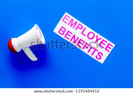 job with social guarantees. Printed words empoyee benefits near megaphone on blue background with computer keyboard top view copy space