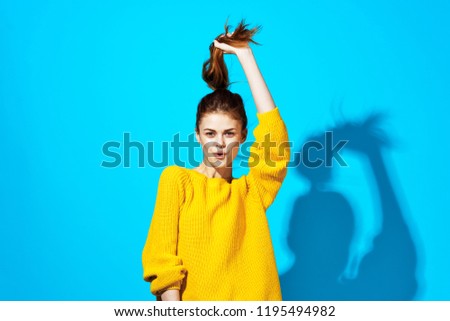 a woman in a yellow sweater lifted her hair up                    