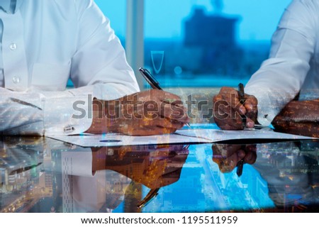 Businessmen hands signing documents on Riyadh skyline city scape background multi exposure Royalty-Free Stock Photo #1195511959
