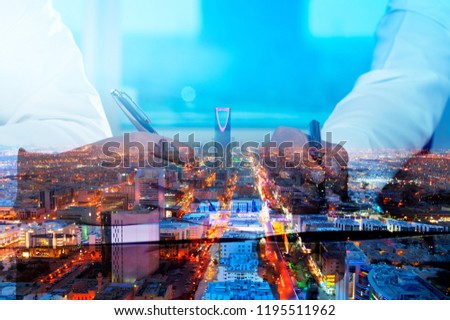 Businessmen hands signing documents on Riyadh skyline city scape background multi exposure Royalty-Free Stock Photo #1195511962