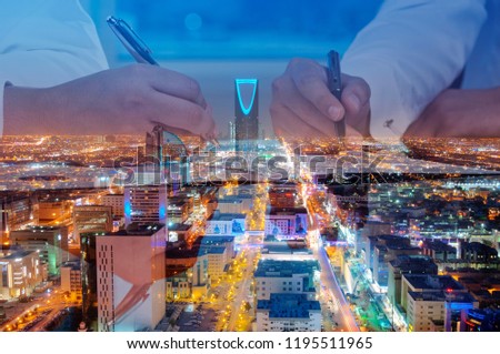 Businessmen hands signing documents on Riyadh skyline city scape background multi exposure Royalty-Free Stock Photo #1195511965