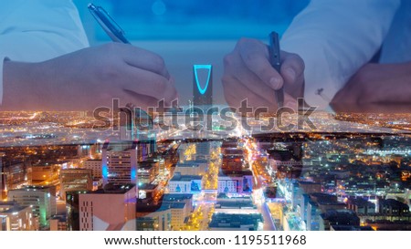 Businessmen hands signing documents on Riyadh skyline city scape background multi exposure Royalty-Free Stock Photo #1195511968