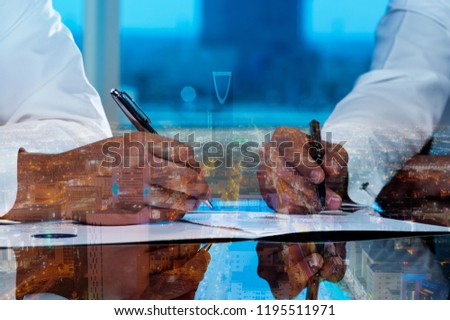 Businessmen hands signing documents on Riyadh skyline city scape background multi exposure Royalty-Free Stock Photo #1195511971