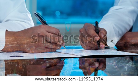 Businessmen hands signing documents on Riyadh skyline city scape background multi exposure Royalty-Free Stock Photo #1195511974