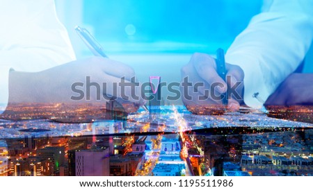 Businessmen hands signing documents on Riyadh skyline city scape background multi exposure Royalty-Free Stock Photo #1195511986