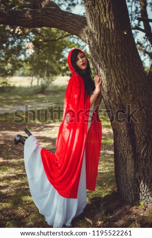 Halloween party concept, mysterious girl in black lace handmade dress and red hood. Beautiful young woman. Inspiration for halloween celebration, ideas and simple nice detail