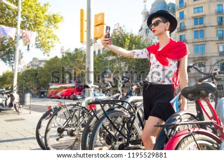 Woman taking selfie self-portrait on smartphone on the street in Barcelona