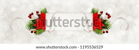 Curled gray silk ribbon and a paper card for text with Christmas tree and poinsettia flowers on holiday background with snowflakes