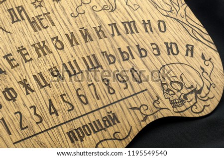 A Ouija Board, yellow on a black background

