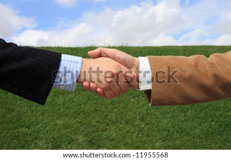 Two business men making a deal with a handshake at the field