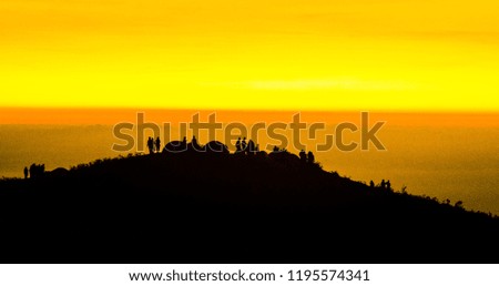 Silhouette of people watching golden sunrise in mount Prau, Dieng. Indonesia.