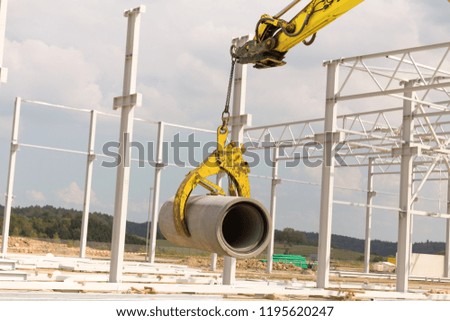construction site excavator with a concrete pipe
