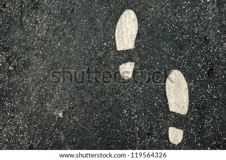 white foot sign on new black asphalt surface for traffic