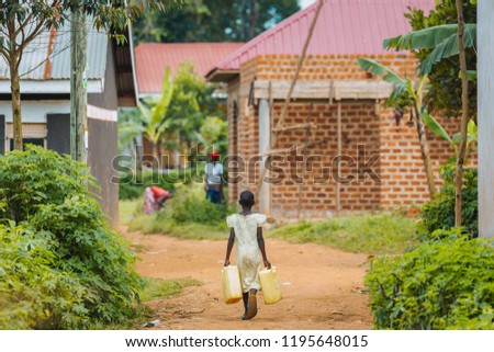child carrying water in Uganda, Africa