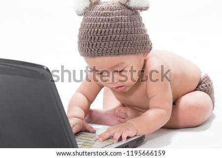 Cute little boy wearing a cap deer sitting in front of the computer isolated on white background.