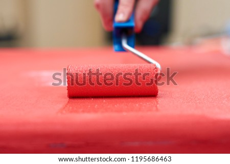 Paint roller with red paint close up