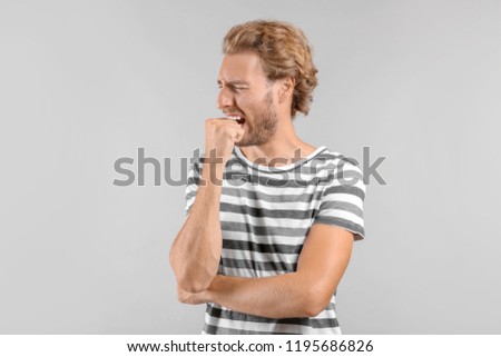 Portrait of stressed man on grey background