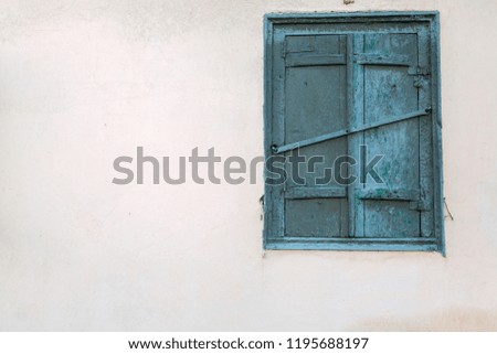 The old wooden window is green. Yellow faded house. Background, texture
