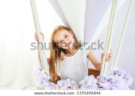 Cute little girl in a white dress standing in the beautiful decorative air balloon