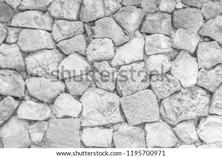 Seamless White pattern of decorative grey slate stone wall surface of modern style design decorative uneven cracked realmasonry wall of multicolored stones or blocks with cement or sandstone.