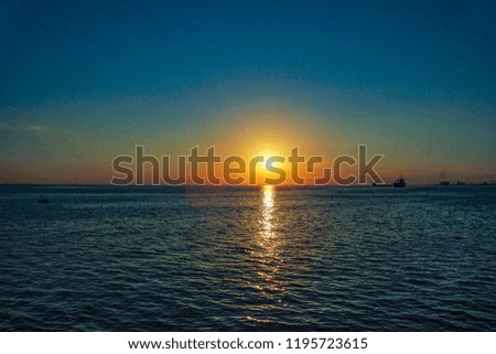the sun ball that will rise on the edge of the horizon with blue sky in the morning