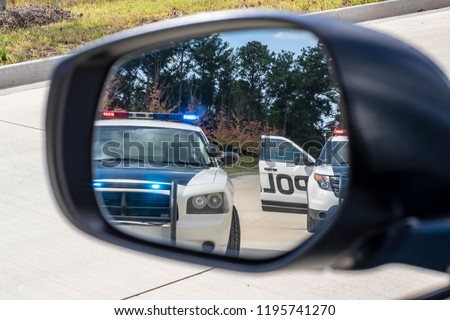 Two police vehicles stop a sedan on a routine traffic stop Royalty-Free Stock Photo #1195741270