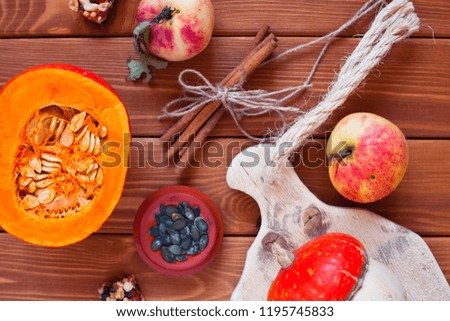  Set of pumpkins, apples and nuts with maple leaves on the wooden background. Autumn mood. Thanksgiving concept. Healthy food, diet, lifestyle and holiday theme. Top view. Close up.
