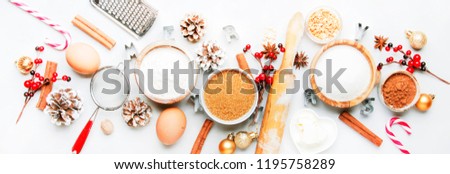 Christmas or New Year composition with ingredients for baking festive cookies, with golden snowflakes, Christmas balls, pine cones on white background, banner, top view