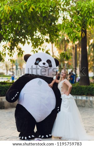 A man in a panda suit comforts an injured woman steps in the city