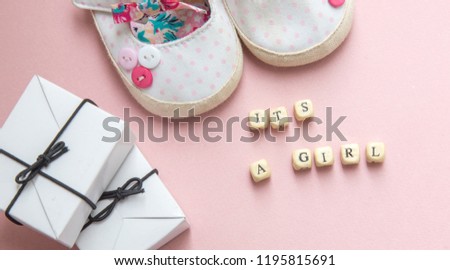 baby shower party. The definition of gender is a little girl or boy. Layout top view in a minimalist style on a pink and blue background. Newborn shoes and gifts