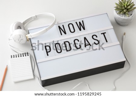 Now Podcast word on lightbox with headphones on white background, podcast concept